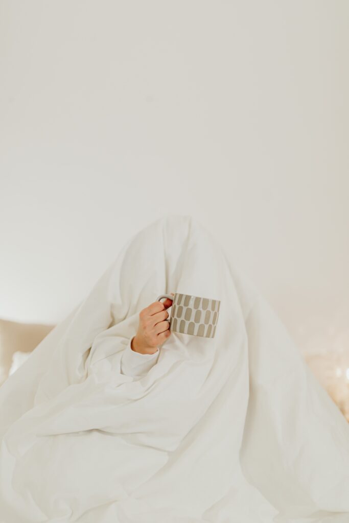 Photo by Karolina Grabowska: https://www.pexels.com/photo/person-hiding-under-a-white-blanket-holding-a-ceramic-mug-6660832/